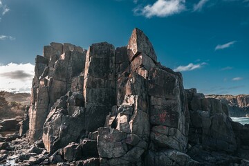 High-angle of a sunlit Bombo Headland geological site rough sea water near