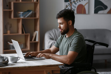 Soldier in wheelchair using laptop at home