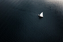 A Lonely Sailboat Sails In The Middle Of The Sea In A Small Swell. Aerial View.