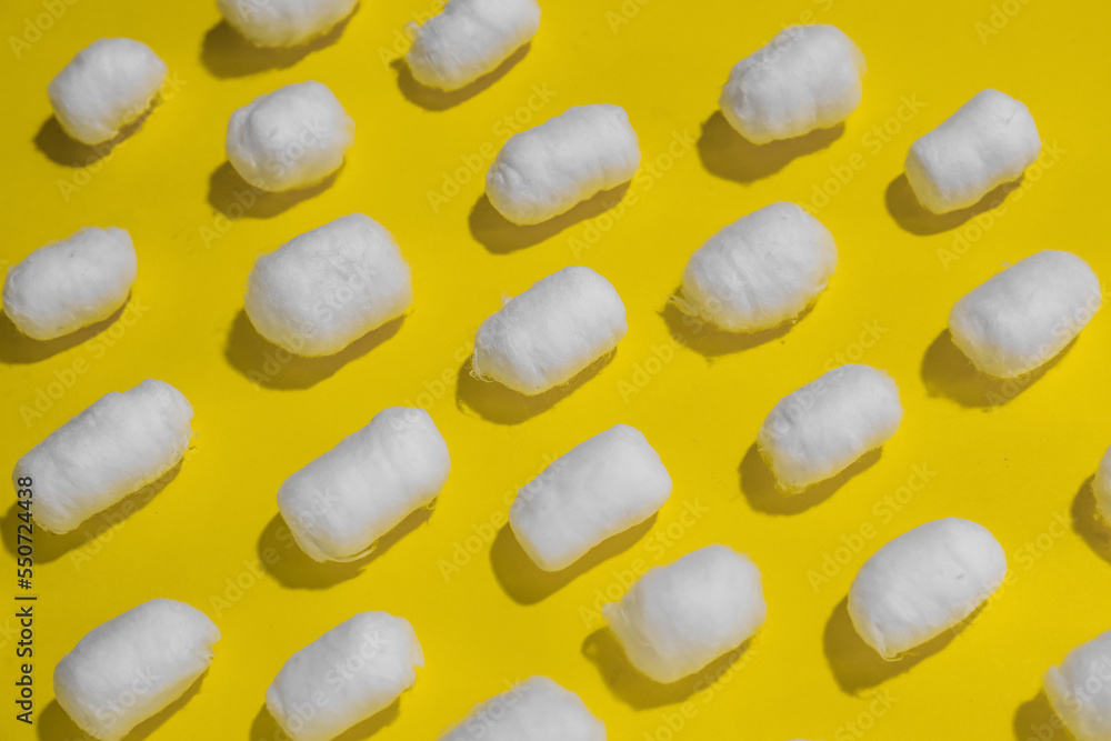 Soft cotton balls on yellow background