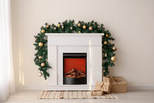 Fireplace With Christmas Branches And Presents Near Light Wall