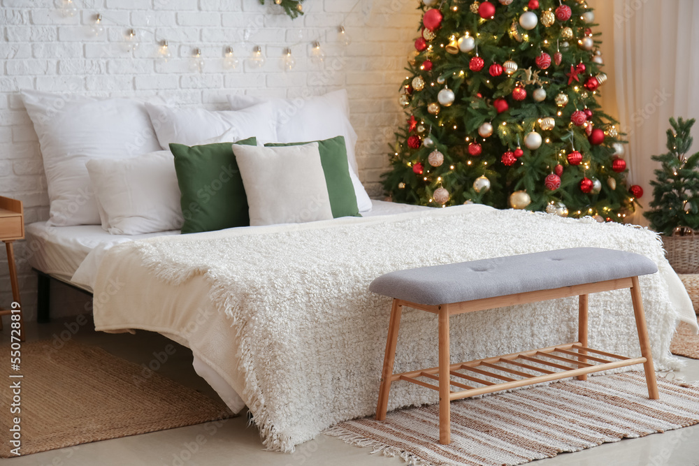Interior of bedroom with Christmas trees and bench