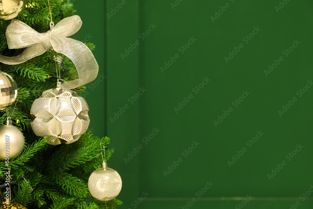 Decorated Christmas tree near green wall, closeup