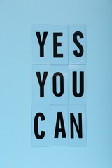 Wall Mural - Phrase Yes You Can of plastic letters on light blue background, top view. Motivational quote