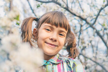 Portrait Of Smiling Girl With Under Flowering Plant