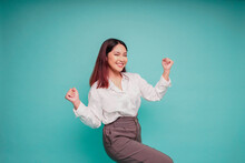 A Young Asian Woman With A Happy Successful Expression Wearing White Shirt Isolated By Blue Background