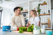 © Graphicroyalty - Smiling young couple cooking food in the kitchen together in the kitchen,having a great time together. Man and woman laughing