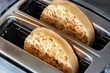 Toasted crumpets cooked in an electric toaster appliance.  On a dark stone background