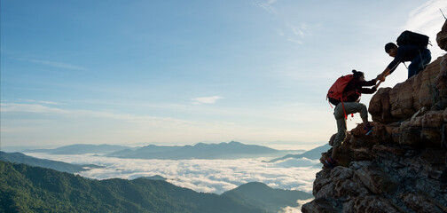 asian hiking help each other on mountains