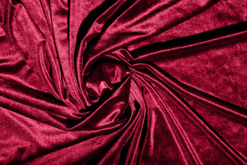 Luxurious cloth background of velvet, velor fabric in trendy color Viva magenta. Concept poster of color of the year 2023.