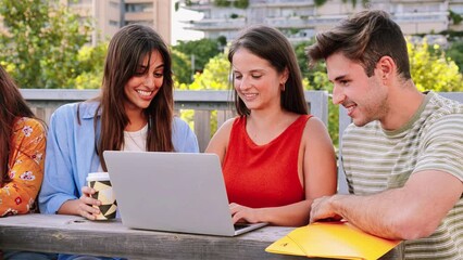 Wall Mural - A group of three young students doing homeworks searching information on internet at university campus with laptop computer. Two happy ladyes and one concentrated guy studing the lesson with a