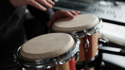 Canvas Print - Musician playing hand Bongo Drums indoors closeup. Man with traditional ethnic folk music instrument