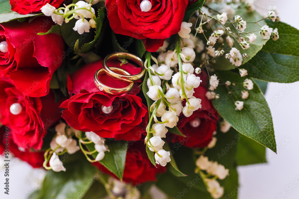 Stock-Foto „Hochzeitsringe Rote Rosen Maiglöckchen Brautstrauss“