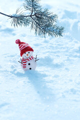 Wall Mural - snowman toy and pine tree branch in snow, natural winter background. New Year and Christmas holiday. festive winter season concept. copy space