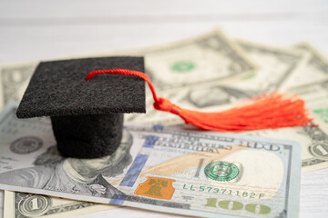 Wall Mural - Graduation gap hat on US dollar banknotes money, Education study fee learning teach concept.