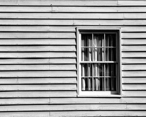 Sticker - Closeup shot of a wooden house window with curtains, on a sunny day, in grayscale