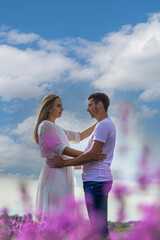 Wall Mural - Beautiful purple lavender flowers in a summer field. couple holding hands.