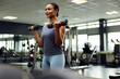 © Flamingo Images - Smiling woman lifting weights at the gym