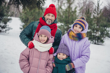 Poster - Photo of cheerful charming husband wife small kids wear windbreakers enjoying snowy weather together outside urban city park