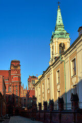 Canvas Print - The belfry of a church and facades of historic tenement houses in Torun