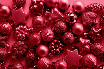 Christmas decoration balls different shapes in viva magenta trendy colors. Top view. Xmas pattern. Happy New Year. Trendy color of the Year 2023.