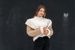 Portrait of smiling girl in white sweater and beige sheepskin coat in studio. Young woman in winter look for every day
