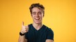 © Robert Peak - Portrait of confident young man 20s with smiling crossing arms nod head yes, giving thumbs up, posing isolated on yellow background studio. People lifestyle emotions concept.
