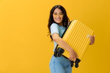 Traveler Woman With Yellow Suitcase, Passport And Ticket In Hand, Paper Plane, Blue T-shirt And Jeans On Yellow Background Tourist, Travel Happiness, Glasses, Copy Space