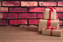 Three Christmas Gift Boxes And Red Brick Wall
