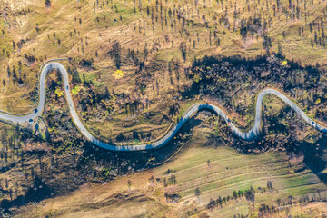 Poster - Aerial view with a curvy road, a sinuous trail in rural area in Romania