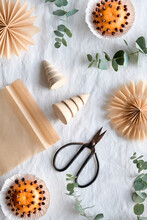 Fragrant Pomander Balls Handmade From Tangerines With Cloves. Handmade Paper Stars From Brown Baking Paper. Flat Lay On Off White Textile Tablecloth With Eucalyptus. Wood Christmas Tree Toys, Trinkets