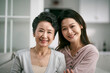 © imtmphoto - portrait of asian senior mother and adult daughter looking at camera smiling