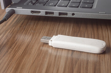 Old modem used to connect the internet via cell phone chip, being docked to a notebook with hand holding