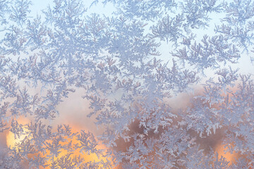 Wall Mural - snow frost in the form of natural patterns on the window pane against the background of the morning 