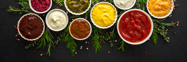 Different types of sauces in bowls with seasonings banner, rosemary and dill, thyme and and peppercorns, top view, copy space