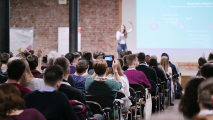 speaker at conference make a poll from the scene. business and entrepreneurship concept. audience at