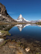 The peak of the Matterhorn Mountain reflects in a lake