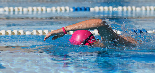 Wall Mural - Swimmer man athlete swimming in pool lanes doing a crawl lap. Swim race freestyle. Triathlete training for triathlon