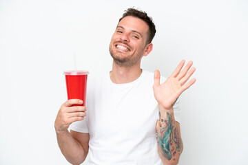 Wall Mural - Young caucasian soda holding soda isolated on white background saluting with hand with happy expression