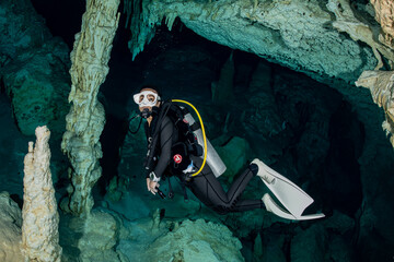 Canvas Print - cave diver instructor leading a group of divers in a mexican cenote underwater