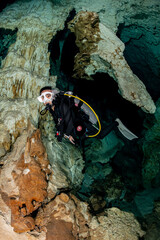 Wall Mural - cave diver instructor leading a group of divers in a mexican cenote underwater