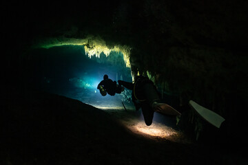 cave diver instructor leading a group of divers in a mexican cenote underwater