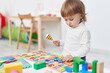 © Krakenimages.com - Adorable hispanic girl playing with maths puzzle game standing at kindergarten