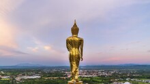 Golden Standing Buddha Statue Overlook City On Mountain At Wat Phrathat Khao Noi Temple; Zoom Out – Time Lapse