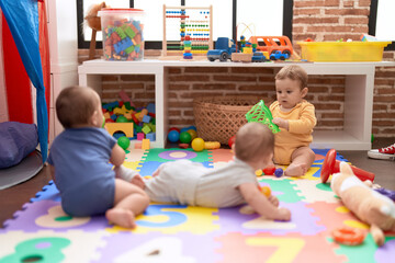 Wall Mural - Group of toddlers playing with toys crawling on floor at kindergarten