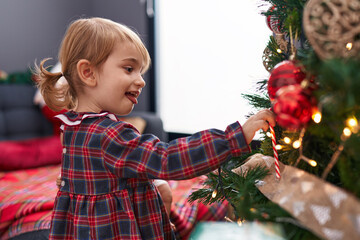 Canvas Print - Adorable caucasian girl smiling confident decorating christmas tree at home