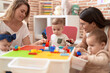 © Krakenimages.com - Teachers and preschool students playing with construction blocks sitting on table at kindergarten