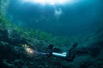  cave diver instructor leading a group of divers in a mexican cenote underwater
