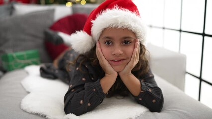 Sticker - Adorable hispanic girl smiling confident lying on sofa by christmas tree at home