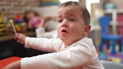 Poster - adorable girl and boy sitting on table fighting at kindergarten